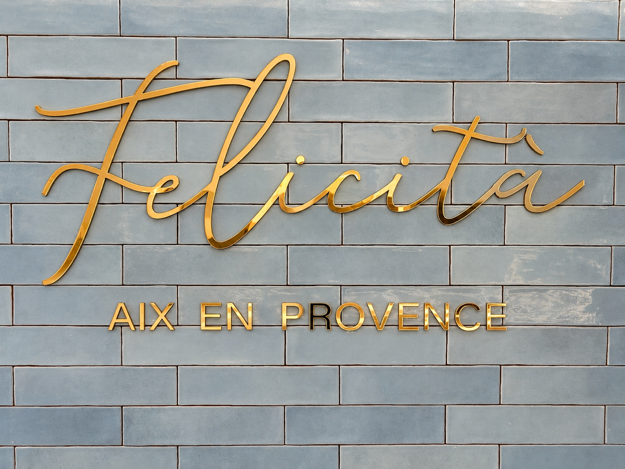 L'enseigne dorée Félicità sur la céramique bleu ciel du bar L'enseigne dorée Félicità sur la céramique bleu ciel du bar